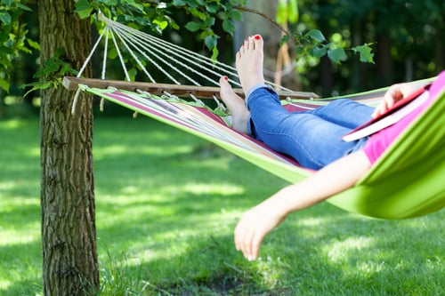 Young lady resting on hammock with book summer Young lady resting on hammock with book summer