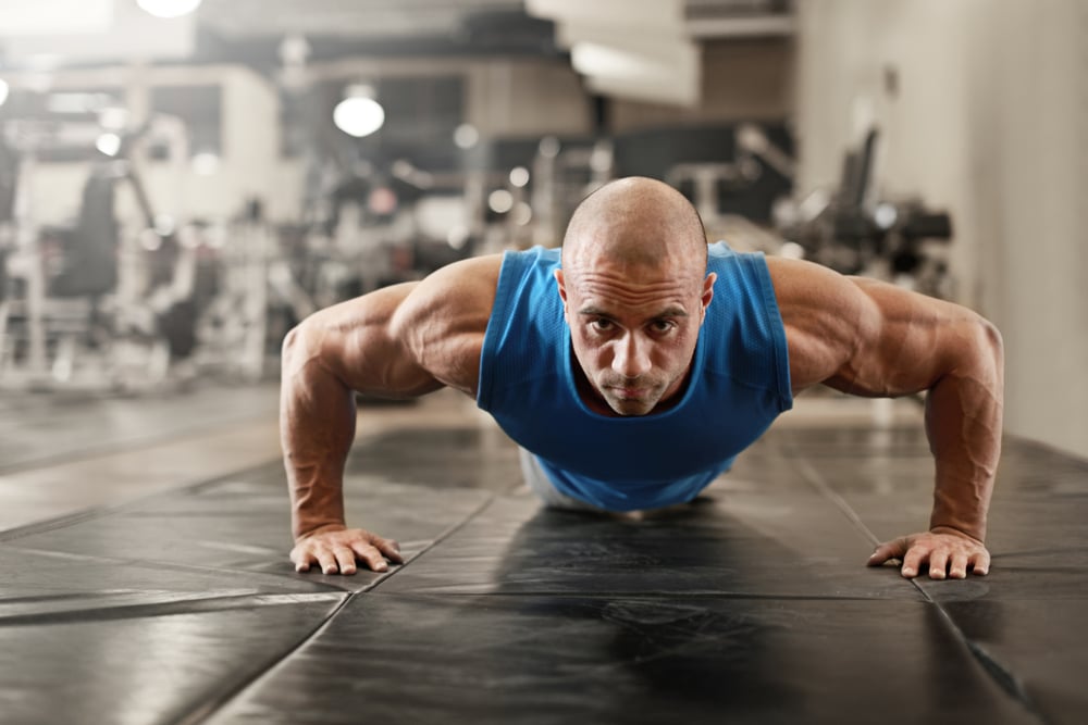 bodybuilder working out and doing push upsat the gym while bodybuilder working out and doing push upsat the gym while
